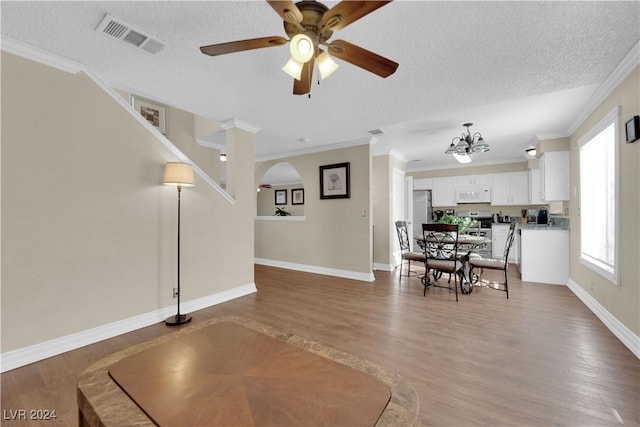 dining room featuring ceiling fan with notable chandelier, a textured ceiling, and crown molding