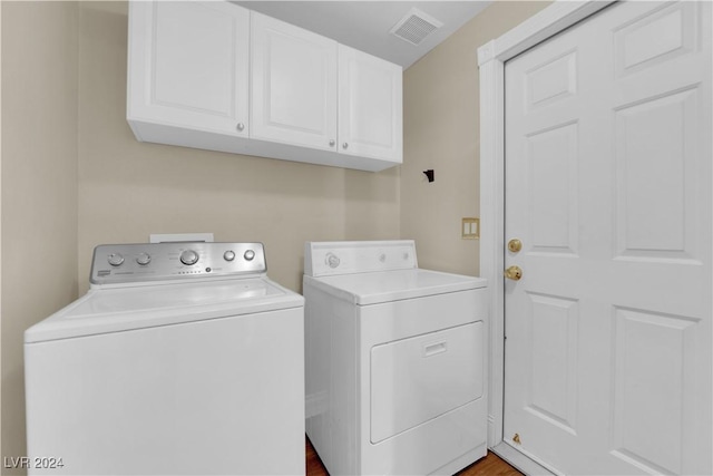 washroom with separate washer and dryer and cabinets