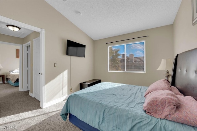 carpeted bedroom with a textured ceiling and vaulted ceiling