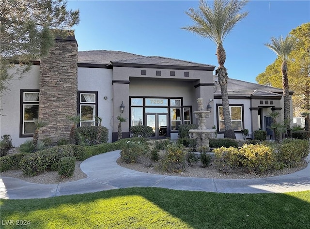 back of house featuring french doors and stucco siding