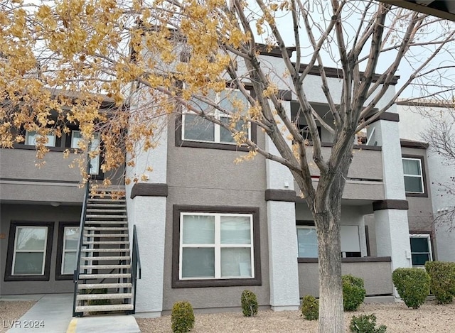 view of front of property with stairs and stucco siding