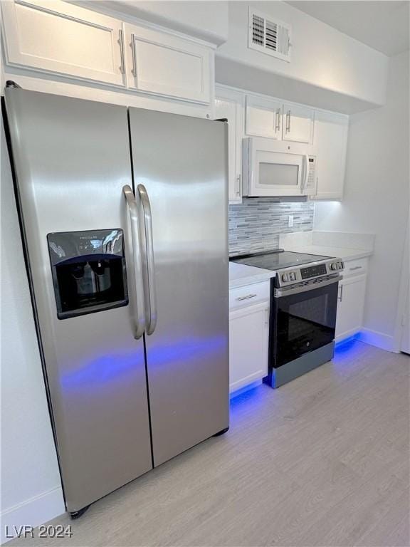 kitchen with white cabinetry, visible vents, appliances with stainless steel finishes, and light wood-style floors