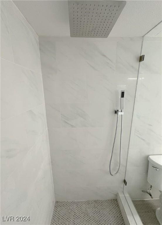 full bathroom featuring toilet, tile walls, and a marble finish shower