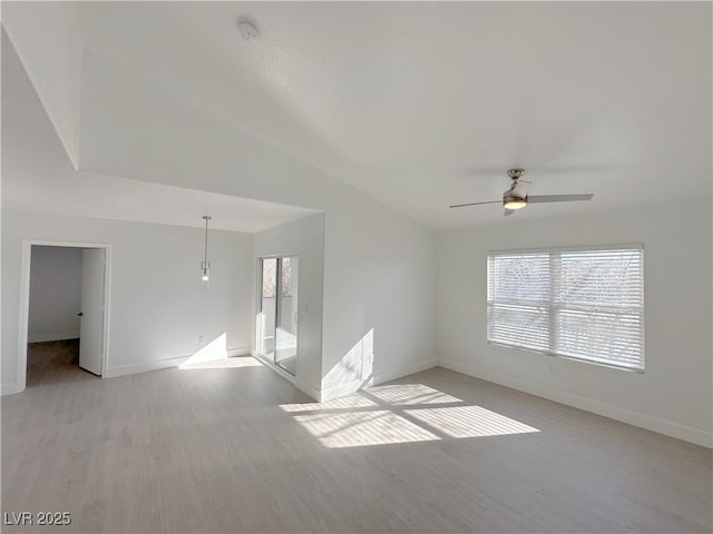 unfurnished room featuring a ceiling fan, baseboards, vaulted ceiling, and light wood finished floors