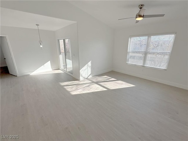 spare room with a ceiling fan, baseboards, and light wood finished floors