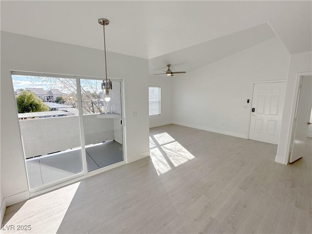 interior space featuring vaulted ceiling, ceiling fan, baseboards, and light wood-style floors