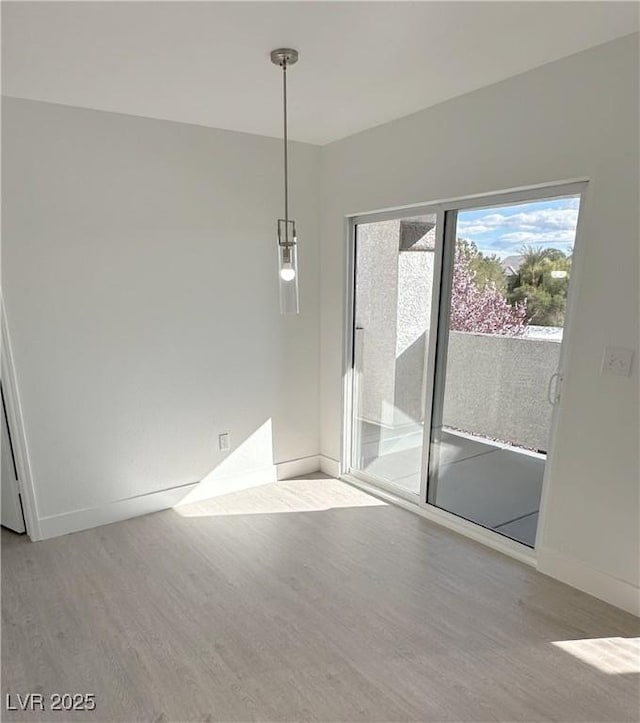 empty room with baseboards and wood finished floors