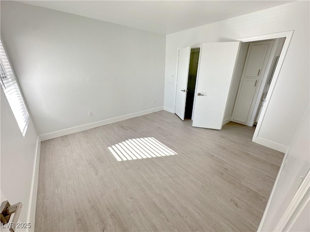 unfurnished bedroom with baseboards and light wood-style floors