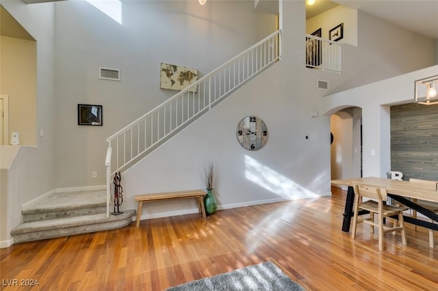 interior space with wood-type flooring and a towering ceiling