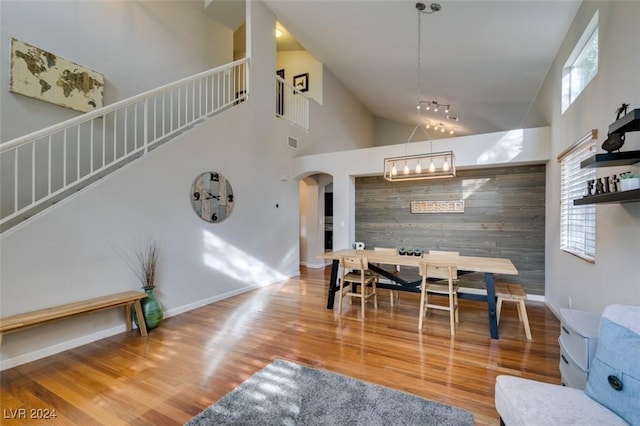 dining area with hardwood / wood-style floors and a high ceiling