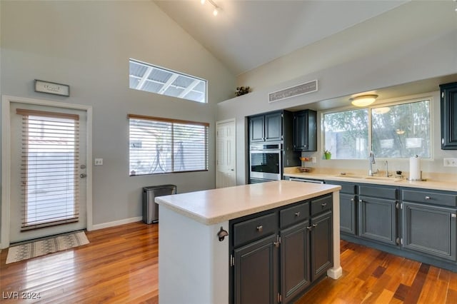 kitchen featuring a center island, sink, oven, and a healthy amount of sunlight