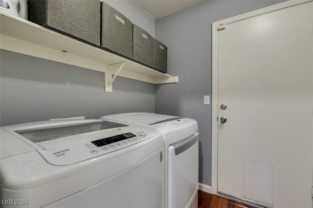 washroom featuring washing machine and dryer, dark hardwood / wood-style flooring, and cabinets