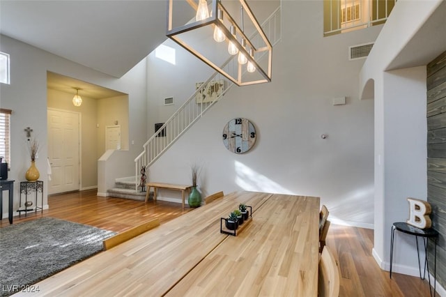 dining space with wood-type flooring and a high ceiling