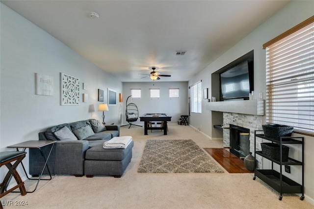 living room featuring ceiling fan, carpet floors, and a fireplace