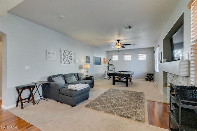 living room with hardwood / wood-style flooring, ceiling fan, and a fireplace