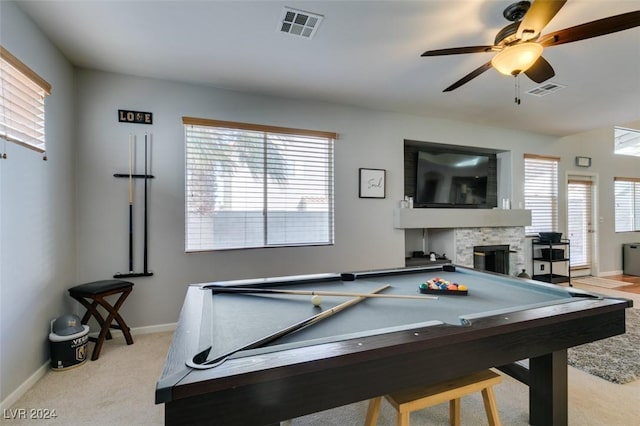 playroom featuring light colored carpet, a stone fireplace, ceiling fan, and pool table