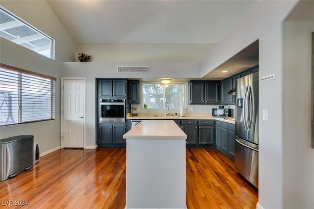 kitchen with a center island, sink, a wealth of natural light, appliances with stainless steel finishes, and dark hardwood / wood-style flooring