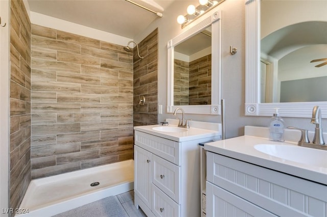 bathroom with a tile shower, ceiling fan, and vanity