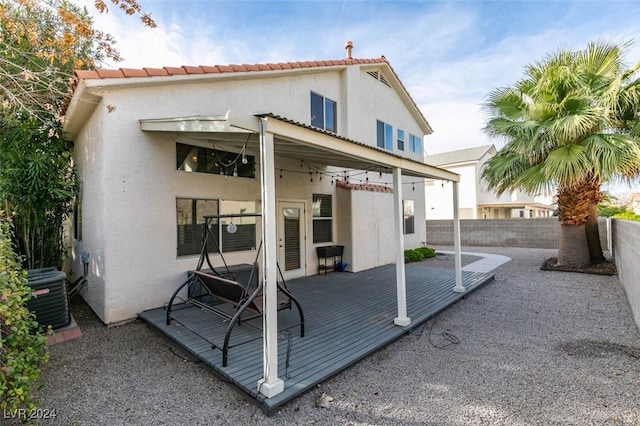 rear view of property featuring a deck and central AC unit