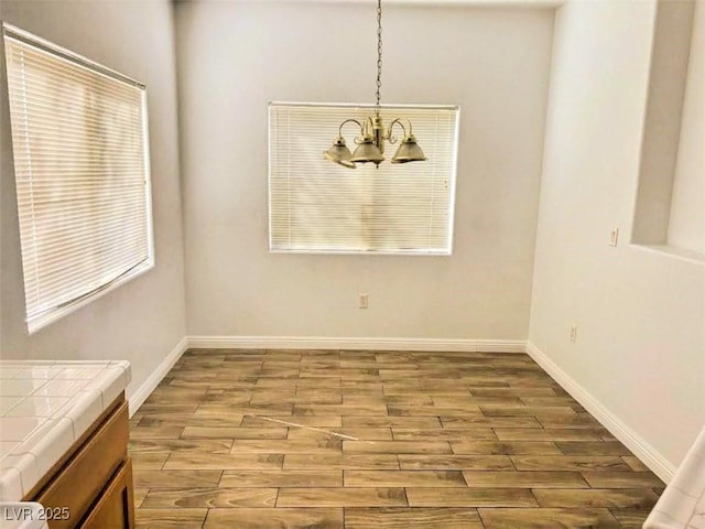 unfurnished dining area with a notable chandelier and light hardwood / wood-style floors