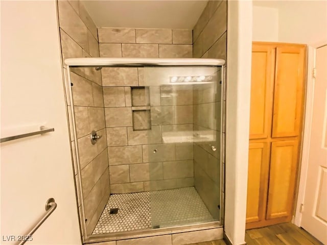 bathroom featuring hardwood / wood-style floors and a shower with door