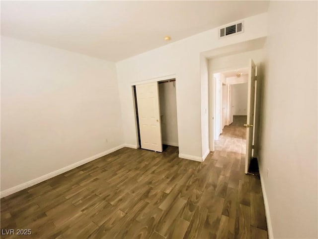 unfurnished bedroom featuring dark hardwood / wood-style floors and a closet