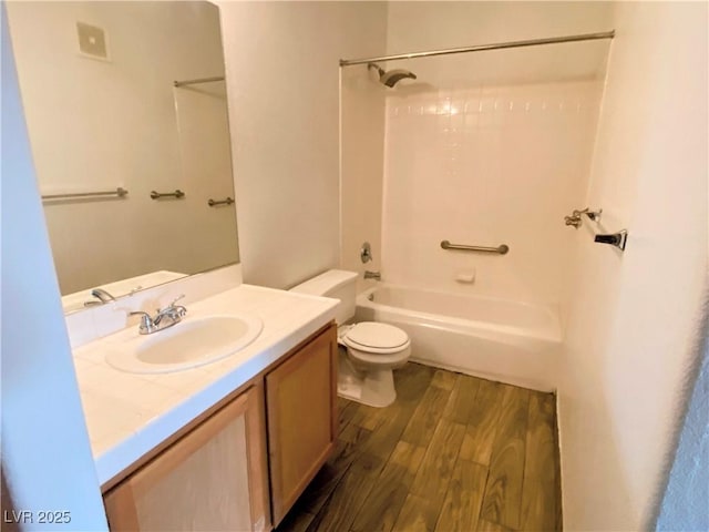 full bathroom with shower / washtub combination, toilet, hardwood / wood-style floors, and vanity