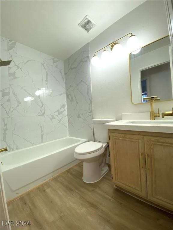 full bathroom with wood-type flooring, toilet, vanity, and tiled shower / bath