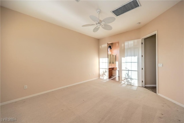 empty room featuring light colored carpet and ceiling fan