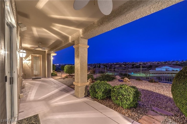 patio at night featuring ceiling fan