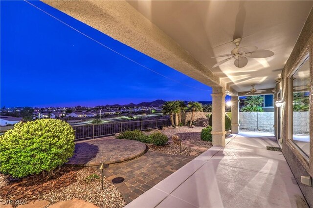 patio terrace at dusk featuring ceiling fan