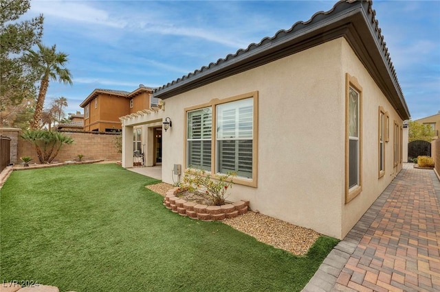 back of property featuring a patio and a lawn