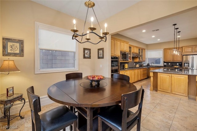 tiled dining room with sink and a chandelier