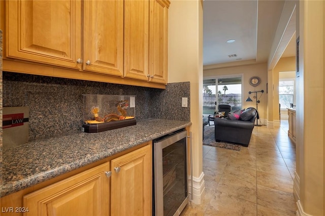 kitchen featuring dark stone counters, light tile patterned floors, beverage cooler, and tasteful backsplash