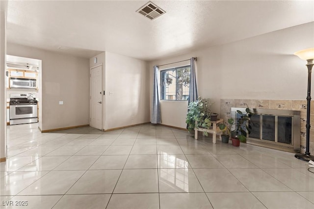 foyer featuring a tile fireplace and light tile patterned flooring