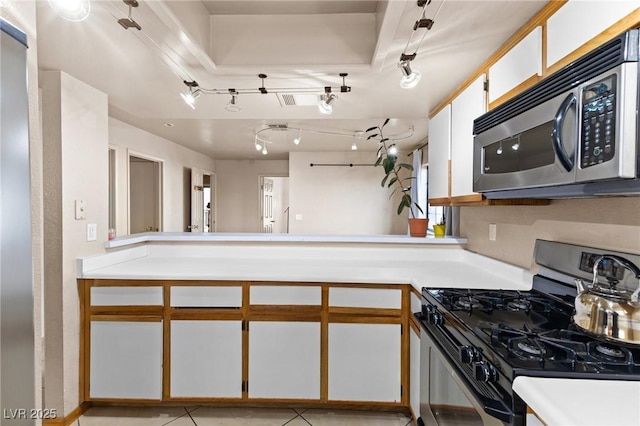 kitchen featuring kitchen peninsula, white cabinets, and appliances with stainless steel finishes