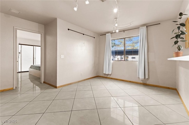 spare room featuring light tile patterned floors and track lighting