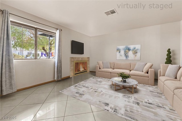 living room with a fireplace and light tile patterned floors