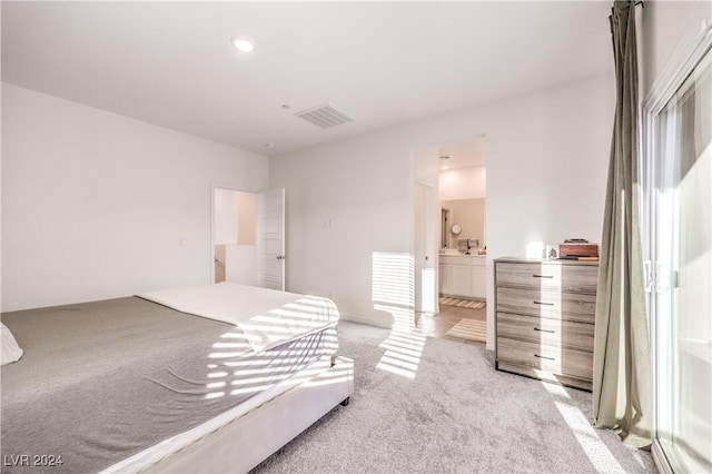 bedroom featuring light colored carpet, connected bathroom, and multiple windows