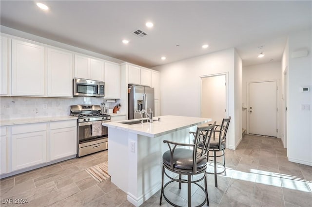 kitchen with a center island with sink, sink, white cabinetry, and stainless steel appliances