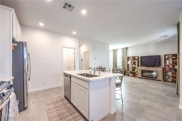 kitchen featuring a center island with sink, white cabinetry, sink, and stainless steel appliances