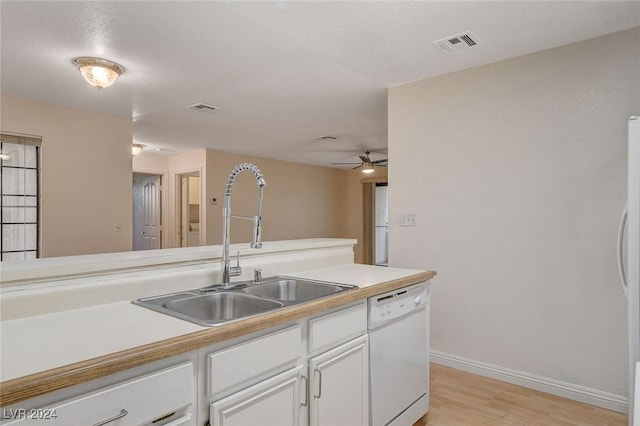 kitchen with white cabinetry, sink, ceiling fan, white dishwasher, and light wood-type flooring