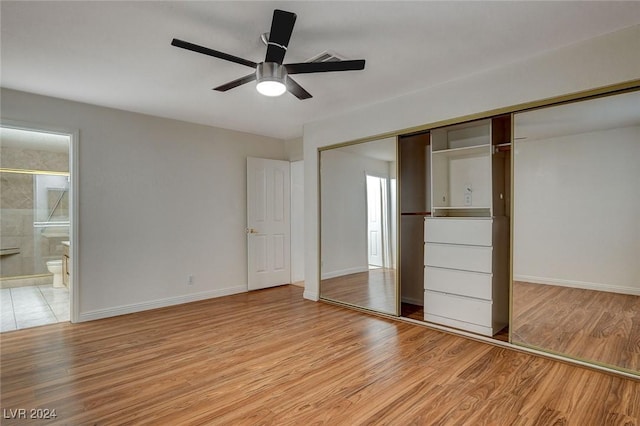 unfurnished bedroom featuring connected bathroom, light hardwood / wood-style floors, a closet, and ceiling fan