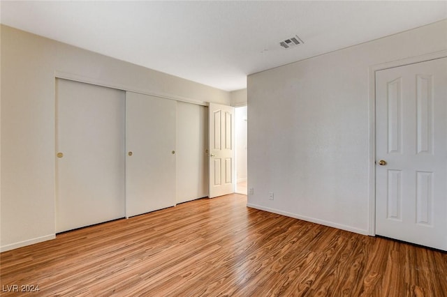 unfurnished bedroom featuring light hardwood / wood-style floors and a closet