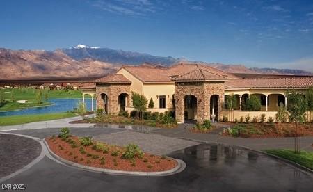 mediterranean / spanish-style house featuring curved driveway and a water and mountain view