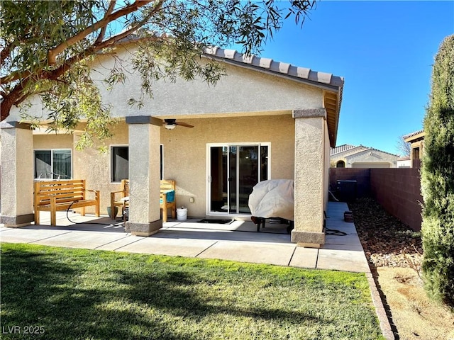 back of property featuring a patio area, fence, a lawn, and stucco siding