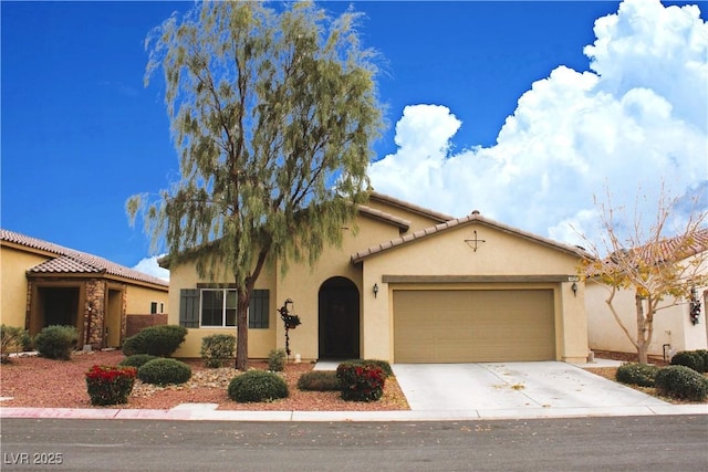 mediterranean / spanish-style home featuring driveway, a tile roof, a garage, and stucco siding