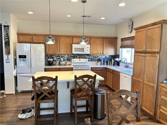 kitchen featuring white appliances, a kitchen island, decorative backsplash, and a sink