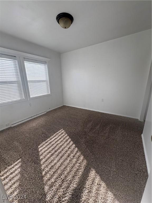 unfurnished room featuring carpet flooring and a baseboard radiator