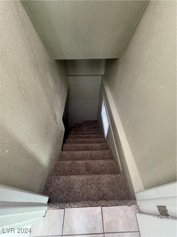 stairway with tile patterned floors